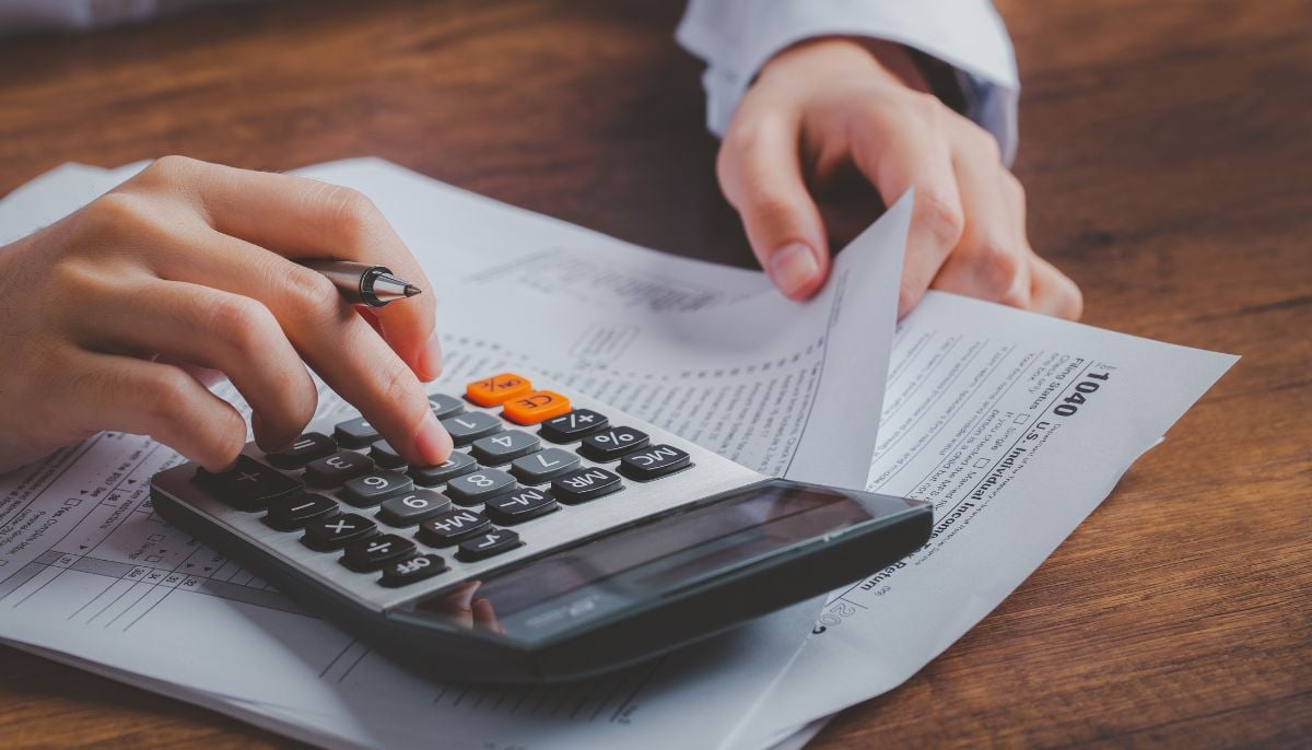 A representational image of a person using a calculator. — Canva