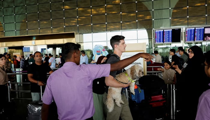 A volunteer guides passengers to their respective gates after several airlines had flight delays after a major technical glitch impacted the check-in systems for airlines, at the Chhatrapati Shivaji Maharaj International Airport in Mumbai, India, July 19, 2024. — Reuters