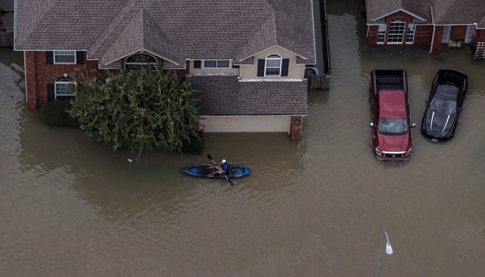 This representational image shows a volunteer searching for evacuees through flood waters in Northwest Houston, Texas, US. — Reuters/File