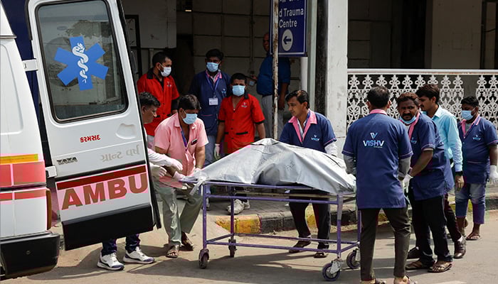 Health workers shift the body of a victim, who died in the plane crash, to a cold storage at a hospital, in the aftermath of an Air India Boeing 787-8 Dreamliner crash during take-off from an airport, in Ahmedabad, India, June 13, 2025. — Reuters